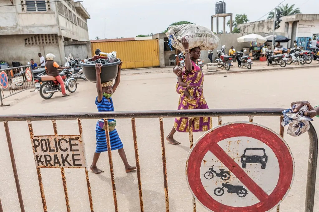 People carry merchandise across the Benin-Nigeria border.
