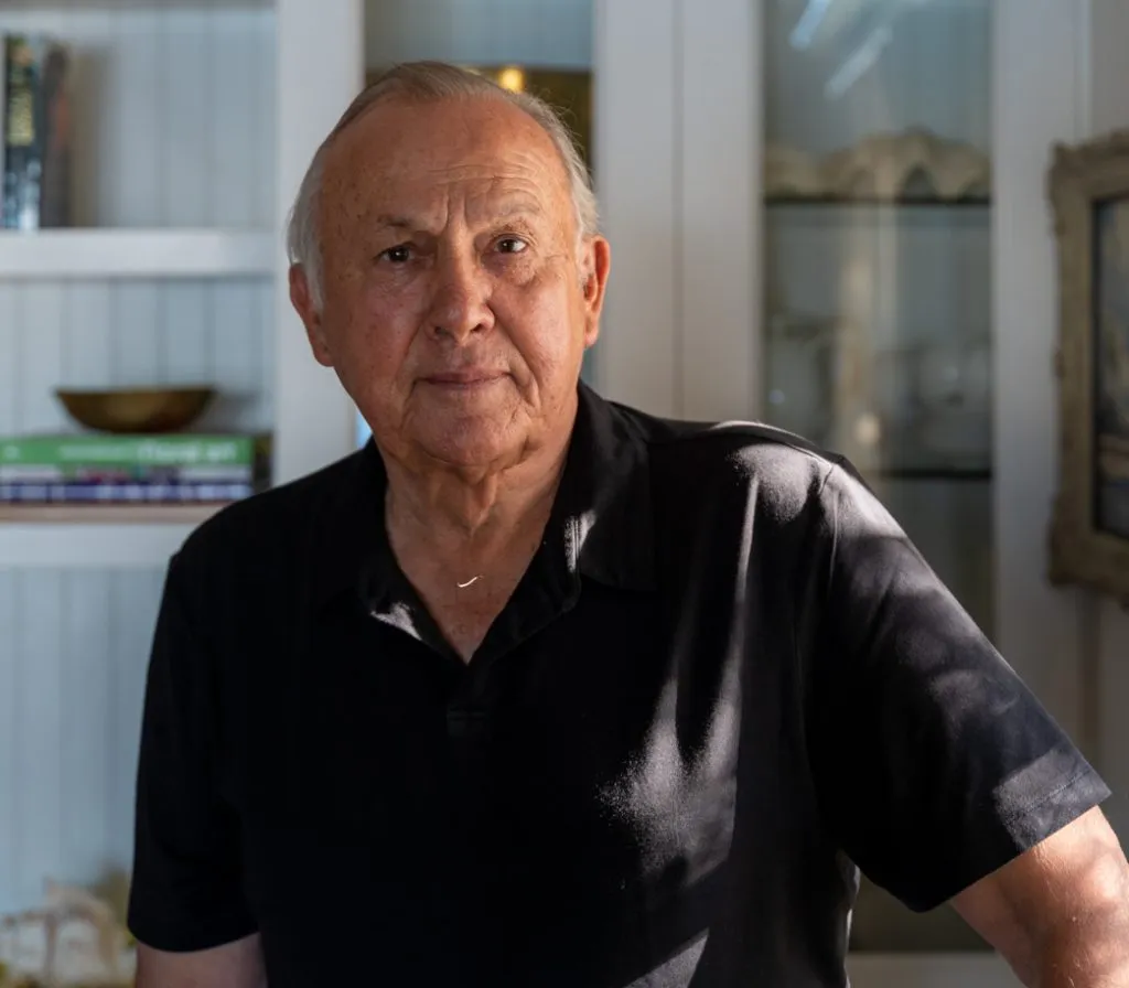 South African billionaire Christo Wiese sitting in front of a bookcase.