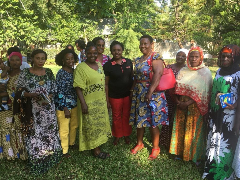 A group of African women with trees in background.